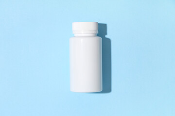 Blank plastic vitamin bottle on blue background