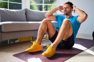 Handsome man doing sit-ups exercise during home workout