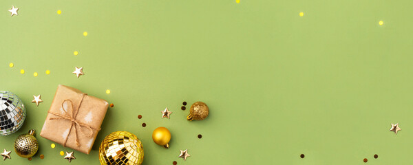 Christmas gift with gold ornaments on a green background.