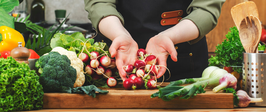 Chef prepares nutritious dishes with colorful vegetables and fresh herbs on cutting board in a modern kitchen setting - Powered by Adobe