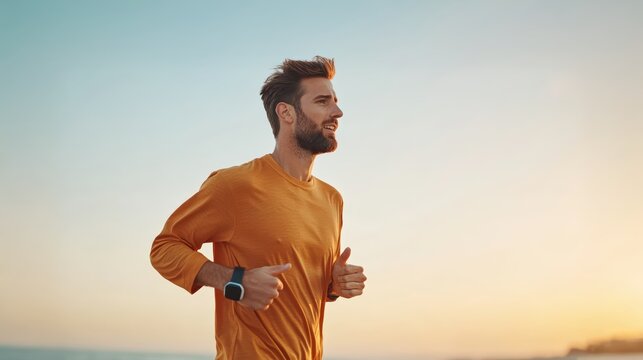 Focused man runner jogging on ocean beach with morning sky at golden sunrise, showing embracing outdoor fitness, well-being, and vitality. Concept of dedication to healthy active lifestyle