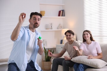 Man and his friends playing darts at home