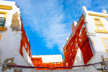 Section of a building partially demolished, contrasts sharply with neighboring, intact structure....