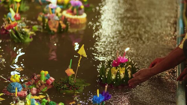 People floating Krathongs on the full moon night, candlelight reflecting on the water, capturing the warmth and faith of Thai tradition