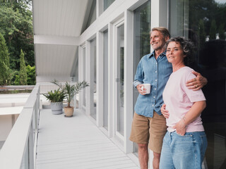 Couple relaxing together on house balcony during summer leisure time
