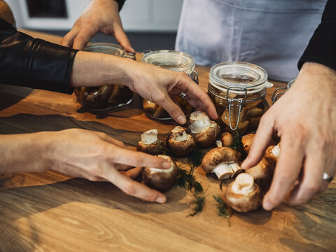 Hands preparing mushrooms in a cooking class for vegetable preserving