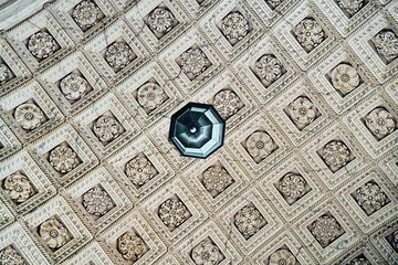 Ornate coffered ceiling adorned with floral rosettes and central light fixture