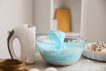 Mixer with whipped blue egg albumen on table in kitchen