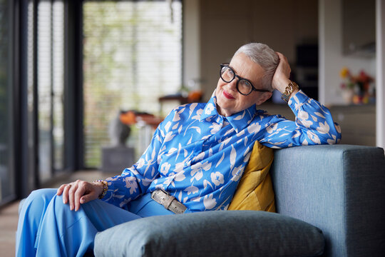 Relaxed senior woman sitting on couch at home