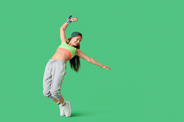 Cool female hip-hop dancer on green background © Pixel-Shot