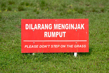 Warning sign with text “Please Don't Step on the Grass” in a public park
