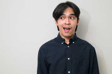 Obraz premium Portrait of handsome Young Asian Thai man surprised looking to side against white background