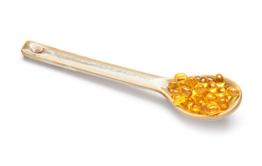 Spoon with vitamin E capsules on white background