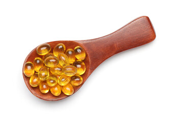 Wooden spoon with vitamin E capsules on white background