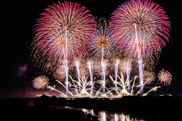 幻想的なピンクと紫の色彩：川面に映るワイドスターマイン