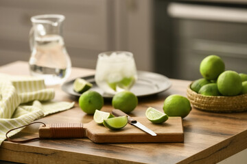 Glass of lime infused water on wooden table in kitchen
