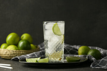 Glass of lime infused water on black background