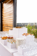 Exquisite canapes in caviar cups on white multi-tiered stands at a luxury event
