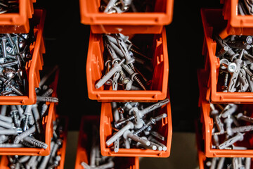 Screws, wall plugs and nuts in orange boxes