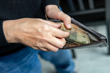 Person holding an open wallet filled with Polish banknotes. Close-up shot representing personal finance, budgeting