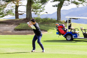 ゴルフを楽しむ日本人のミドル男性
