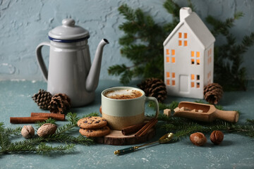 Cup of coffee with cookies, teapot and winter decor on blue grunge background