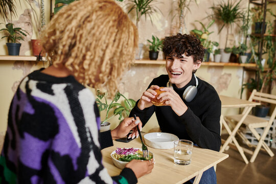 Stylish couple enjoys a delightful lunch together in a cozy cafe filled with plants
