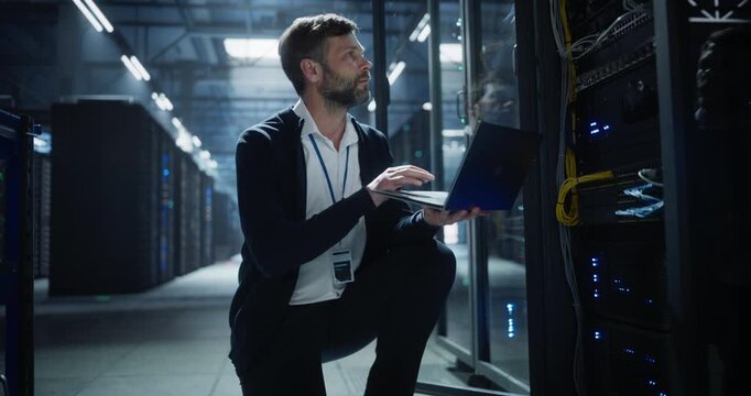 Technician uses a laptop of server rack systems in a data center, analysis of device connections, network cables, electronics for secure business infrastructure, it service, and software operation.