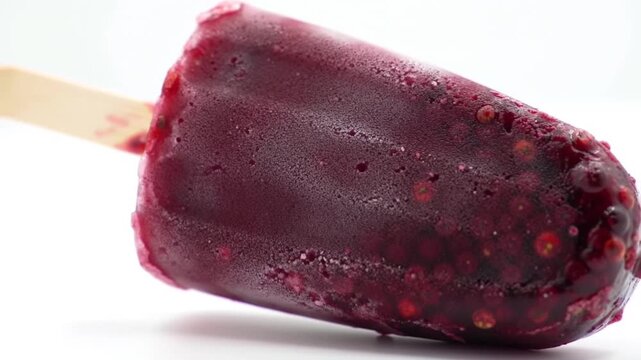 Sorvete de morango vermelho, branco e rosa no palito , uma sobremesa doce em close-up e isolada no branco 