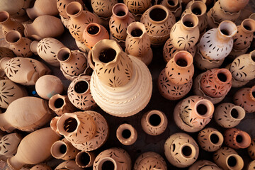 A beautiful collection of traditional Omani clay pottery displayed in Nizwa Souq, showcasing...