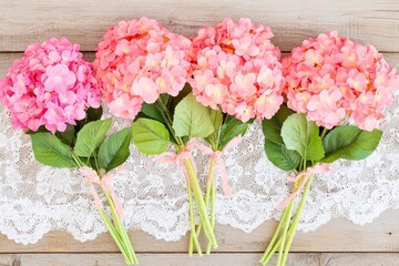 Obraz premium Pink Hydrangeas on Lace Cloth on Antique Table - Floral Arrangement Photography
