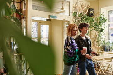 Fototapeta premium Stylish couple enjoying a casual moment together at a cozy cafe surrounded by greenery