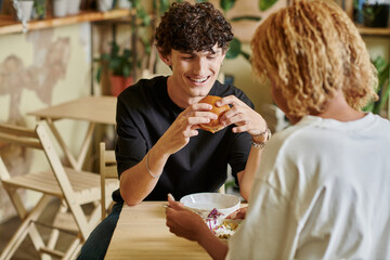 Stylish couple enjoying a meal together in a cozy cafe during a sunny afternoon
