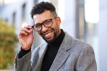 Portrait of smiling man in glasses and suit on city street