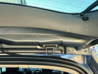 Inspection of car interior showcasing details of the roof frame and hatch mechanism during a sunny...