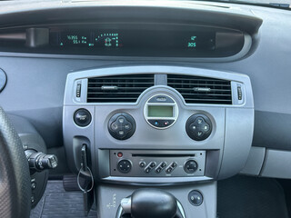 Fototapeta premium Dashboard view of a modern vehicle showcasing digital displays and climate controls on a sunny day
