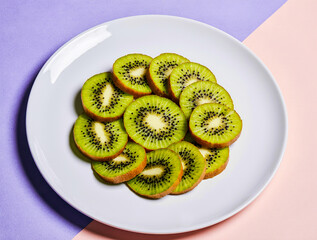 Freshly sliced kiwi fruit arranged on a white plate
