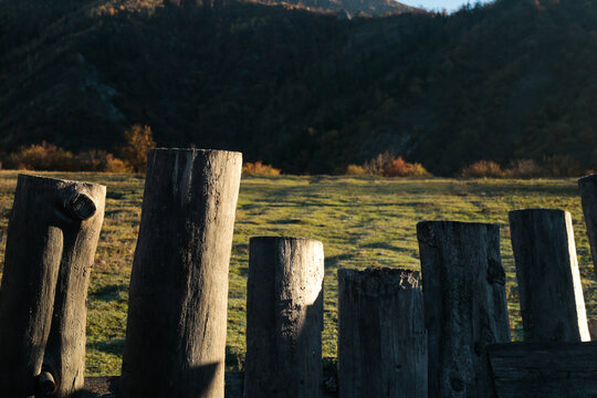 Wooden fence in sunlight on mountain meadow