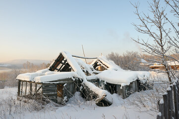 Beautiful rural winter landscape with snow-covered fields, trees, and village houses under a calm cold sky. Peaceful countryside scene.