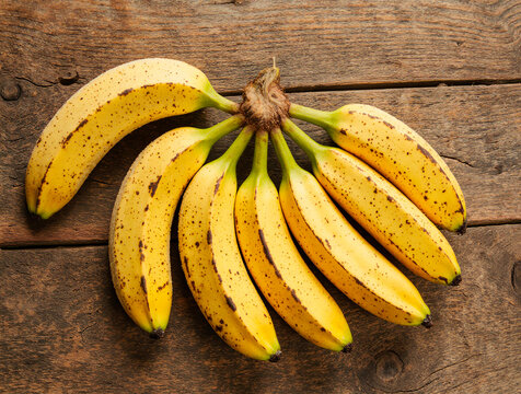 Bunch of ripe yellow bananas on a rustic wooden background