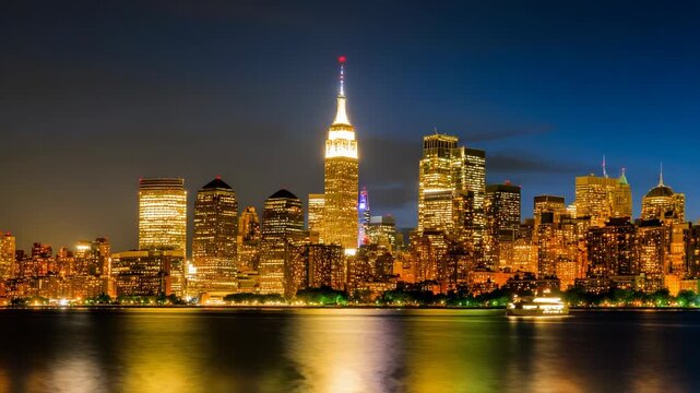 Panoramic skyline view of glowing highrise buildings illuminated at night reflecting in the water, modern urban architecture