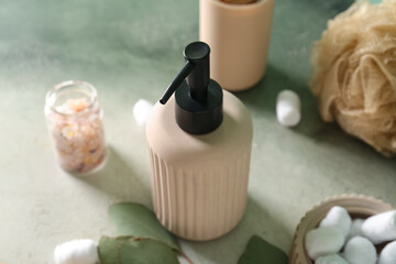 Bottle of cosmetic product, sea salt, sponge and cotton balls on color background, closeup