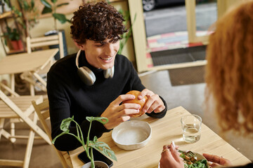 Charming couple enjoys lunch together in a cozy cafe filled with vibrant plants