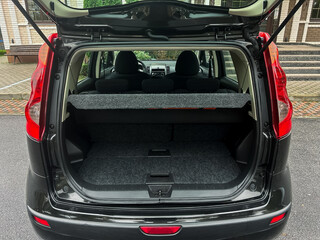 Car trunk filled with luggage at a scenic park, ready for a weekend adventure in the afternoon sun