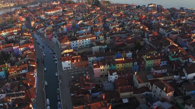 Aerial view of Burano, where vibrant, multicolored buildings line canals, creating a striking contrast against the water, Venice, Veneto, Italy.
