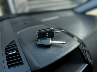 Car keys resting on the dashboard of a vehicle inside a sunlit parking garage during the afternoon