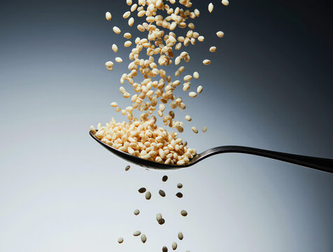 Grains pouring from spoon in mid air against gradient background
