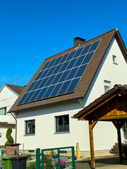Bright sunny day showcases a house with solar panels harnessing renewable energy in a vibrant neighborhood