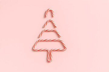 Christmas tree made of candy canes on a light pink background, festive and sweet, christmas