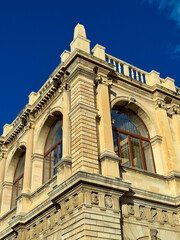 Stunning architectural corner of a historic building under a clear blue sky during the golden hour, showcasing intricate details and craftsmanship